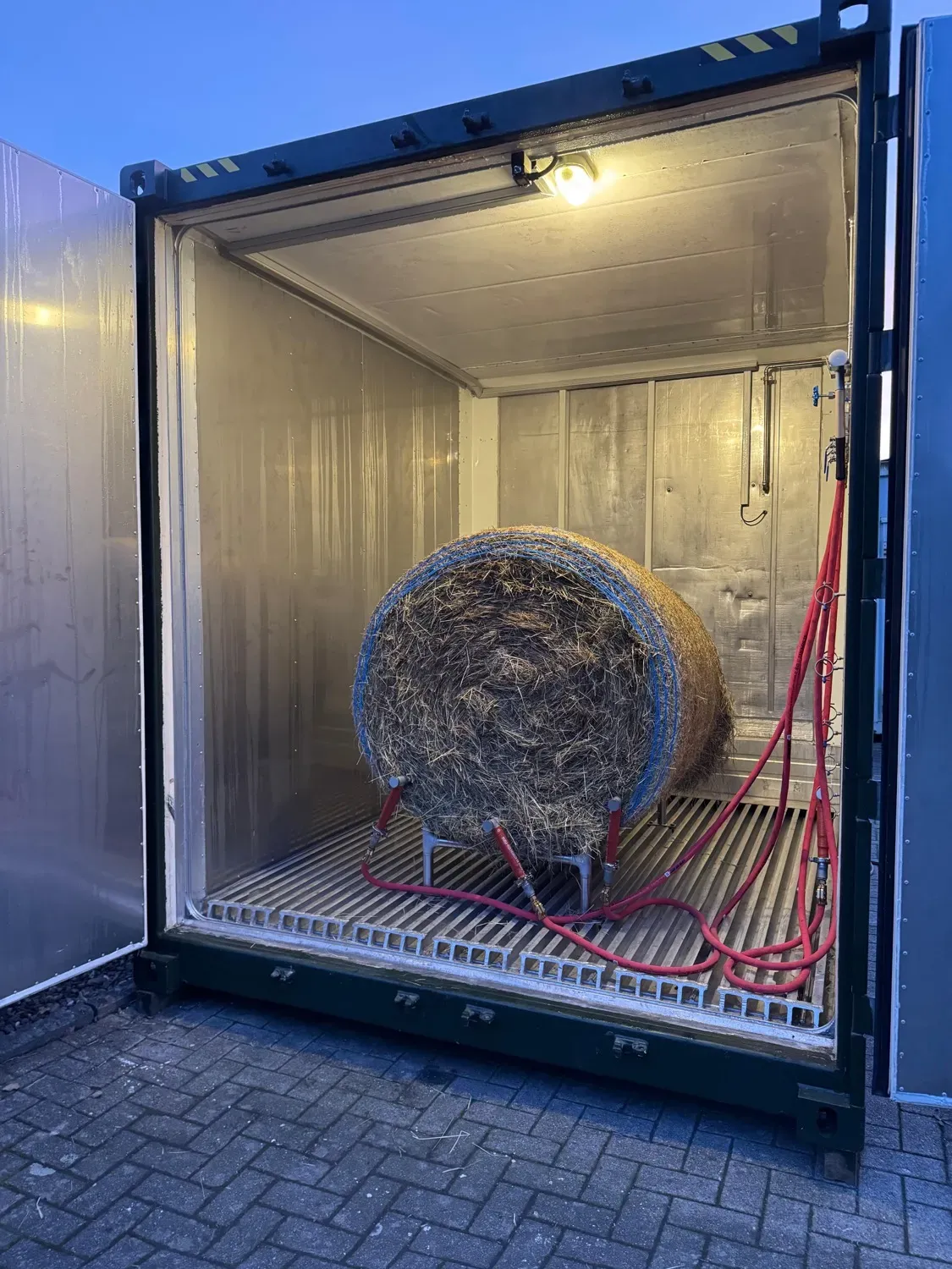 Heubedampfer-Container mit geöffneten Türen und eingelegtem Rundballen